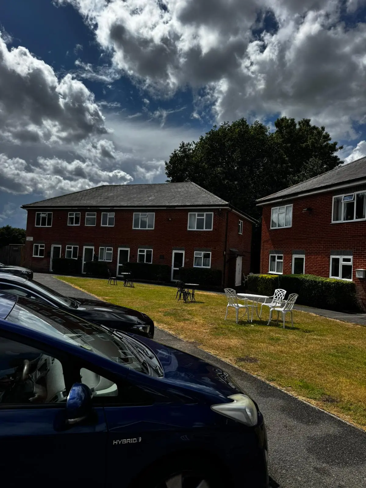 Managed red-brick apartment blocks with communal garden and seating
