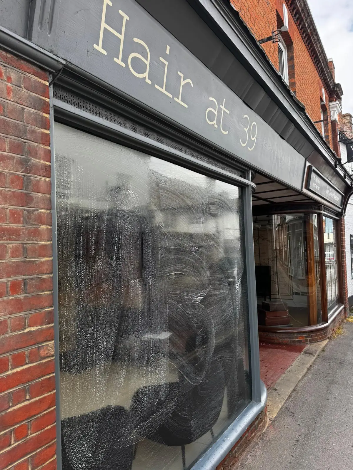 Large display window of the Hair at 39 salon being washed