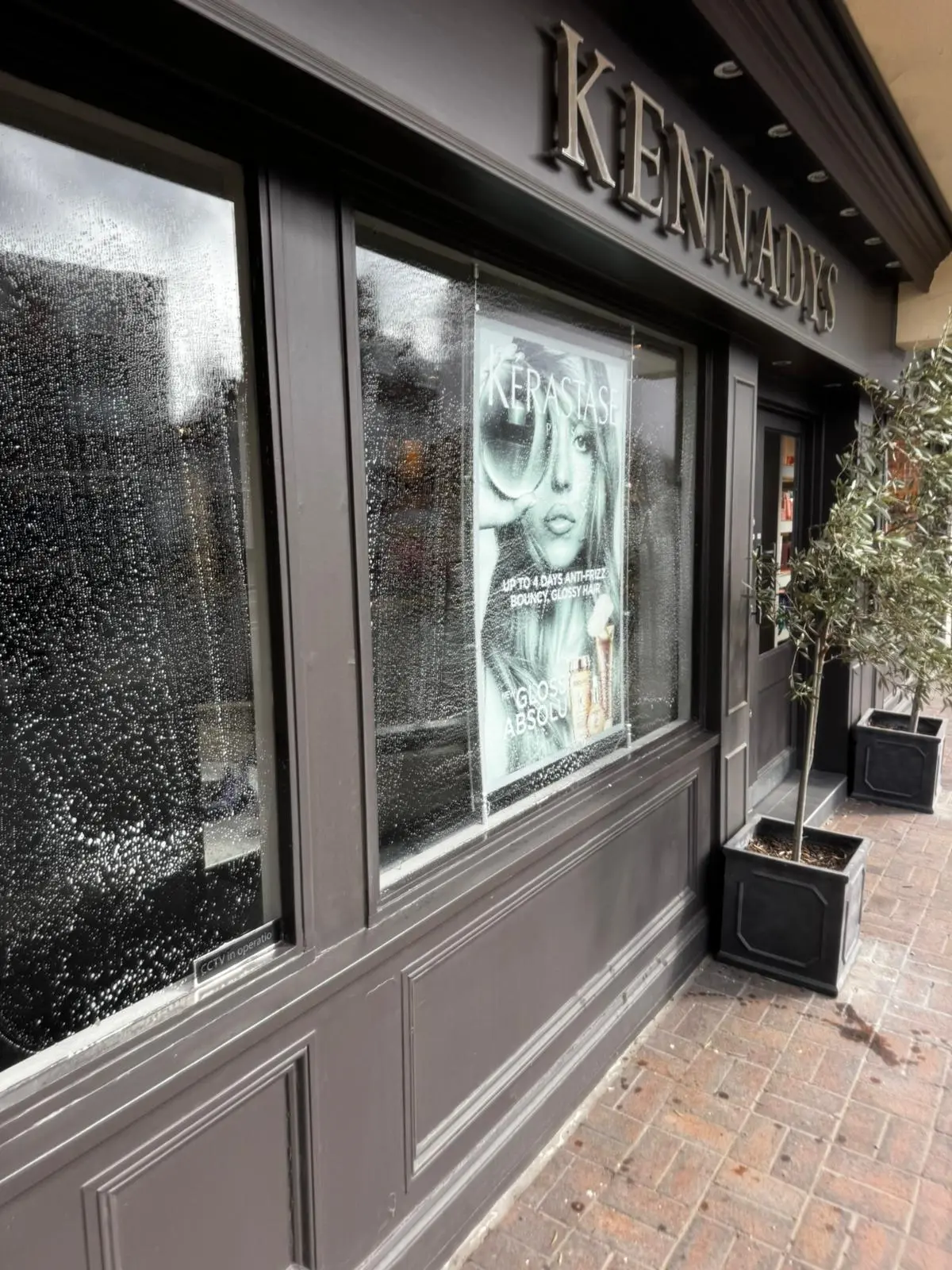 Kennadys hair salon charcoal shopfront window being cleaned before opening
