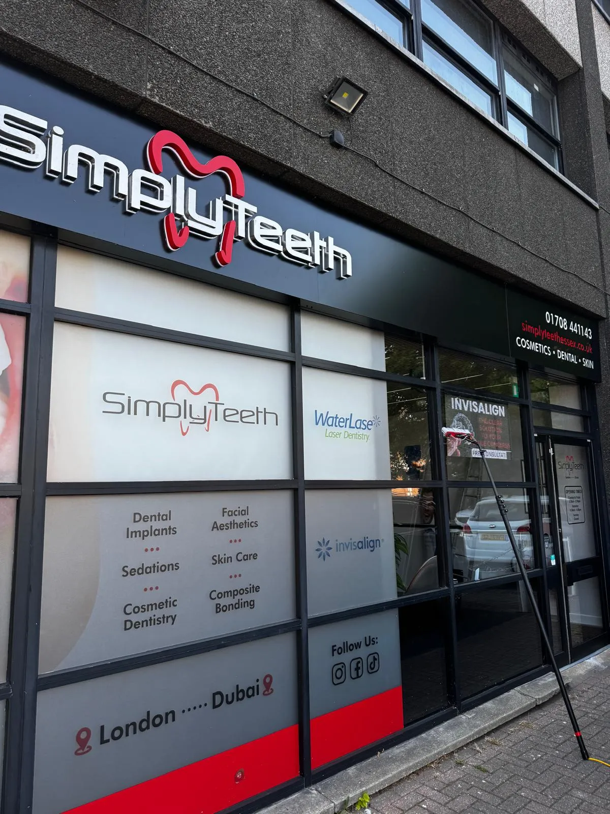 SimplyTeeth dental practice shopfront with large display windows being cleaned using a water-fed pole